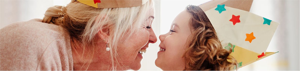 Headerbild – Oma und Kind Spielen zum Geburtstag und stecken die Nasen zusammen – Was tun?| Symbolbild für Nasennebenhöhlenentzündung bei Kindern