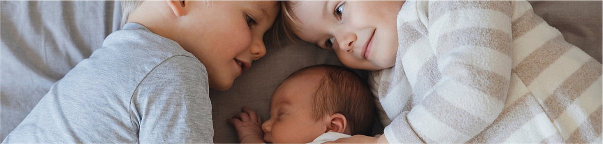 Headerbild: Kleinkind liegt erkältet im Bett – Headerbild zum Thema Husten bei Babys und Kleinkindern"