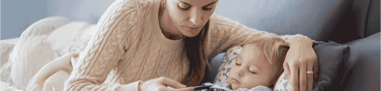 Mutter mit krankem Kind im Bett.